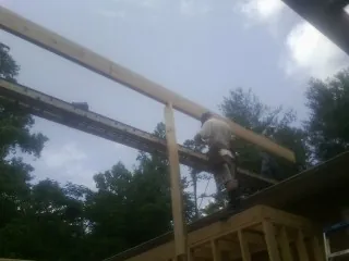 Carpenter setting a ridge beam over a new addition frame — Ice Dam Removal by Roofing Brothers in Hayfield