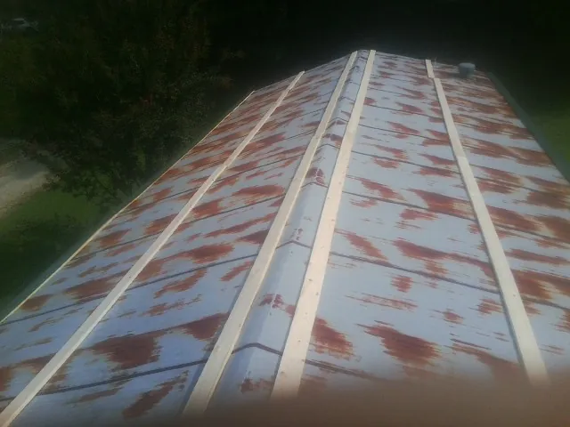 Rusted metal roof panels with new wood purlins before replacement — Storm Damage Roof Repair in Hayfield by Roofing Brothers