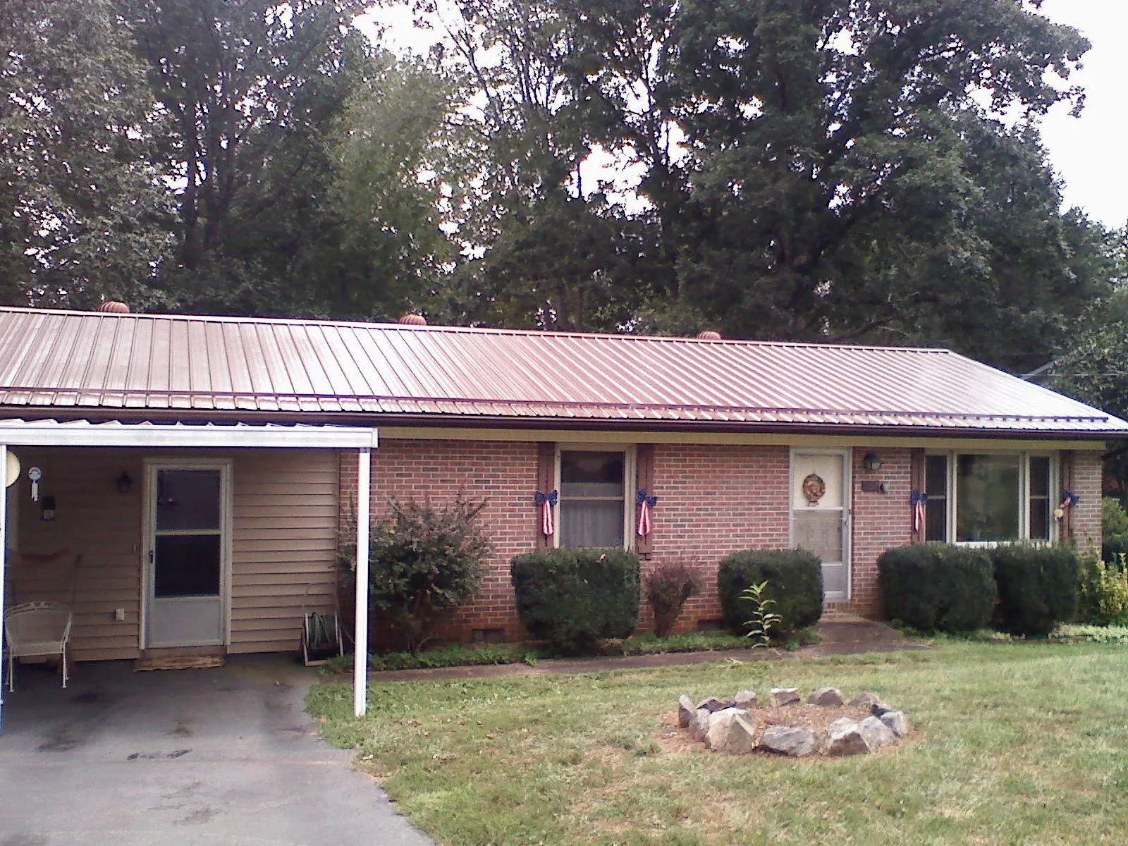 Bronze metal roof and carport on a brick ranch home — Roof Repair work by our crew in Hayfield
